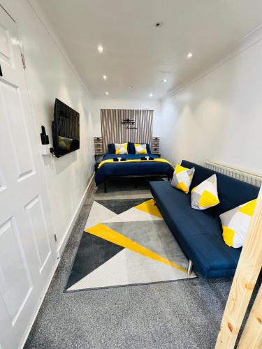 a bedroom with two beds and a couch at AeroSuites Luton - SHARED AND PRIVATE Accommodations mins from Luton Airport,FREE selected Breakfast,Adults Only,FREE Parking subject to availability and reservation only, Whats Up number required, Late Self Check In and Out by request only in Luton