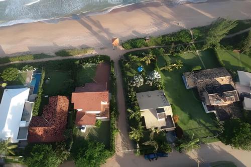 an aerial view of a house next to the beach at Casa das Palmeiras (Pé na Areia) - Maré Verde in Rio das Ostras