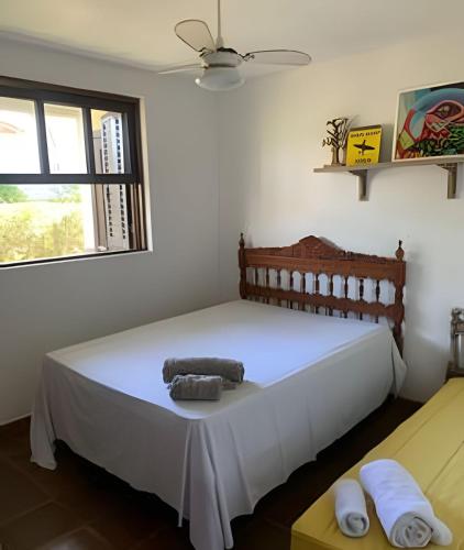 a bedroom with a white bed with towels on it at Casa das Palmeiras (Pé na Areia) - Maré Verde in Rio das Ostras