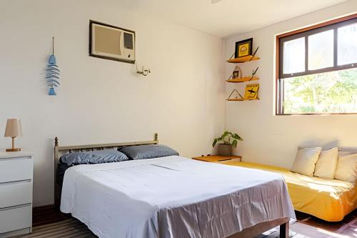 a bedroom with a bed and a tv on the wall at Casa das Palmeiras (Pé na Areia) - Maré Verde in Rio das Ostras