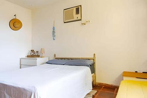 a bedroom with a bed and a tv on the wall at Casa das Palmeiras (Pé na Areia) - Maré Verde in Rio das Ostras