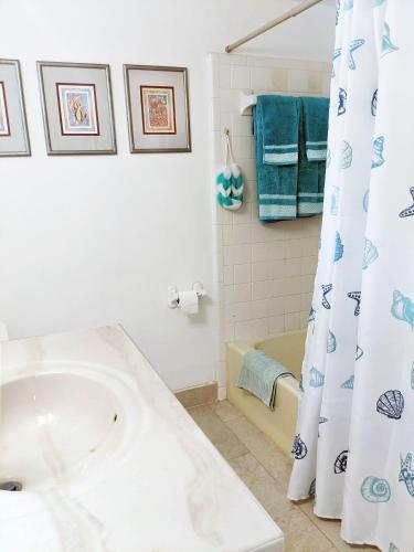 a bathroom with a sink and a bath tub at Beauport One-Bedroom Apartment in Freeport