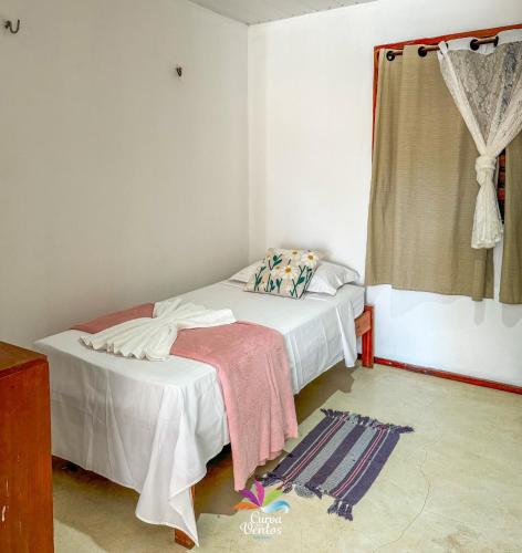 a small bedroom with a bed and a window at Pousada Curva dos Ventos in Icaraí