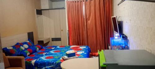 a living room with a bed and a table with a table at Apartemen paragon village in Peusar Dua