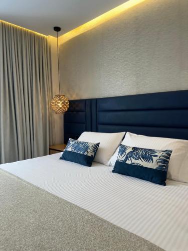 a bedroom with a large bed with blue and white pillows at Hotel y Cabañas Covemar in Coveñas