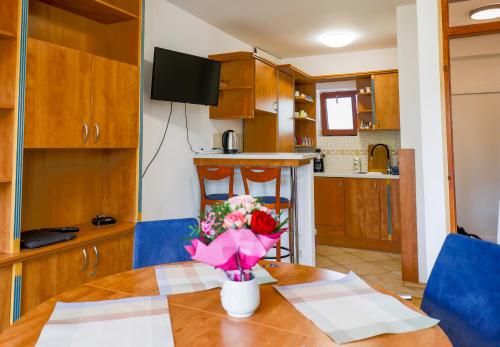 une cuisine avec une table avec un vase de fleurs dessus dans l'établissement Roger Federer apartmanja, à Balatonfüred