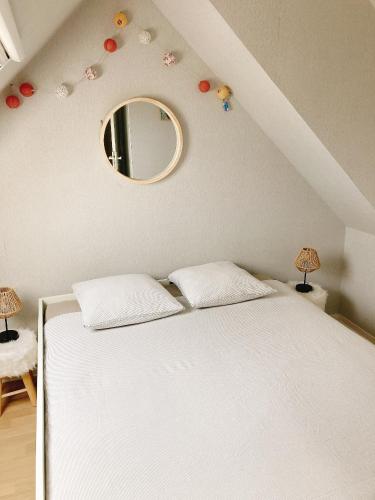 une chambre avec un lit blanc et un miroir dans l'établissement Les SARDINES BLEUES pour 2 à 4 vacanciers, à Carnac