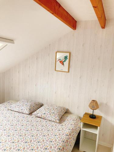 - une chambre dotée d'un lit avec une photo d'oiseau sur le mur dans l'établissement Les SARDINES BLEUES pour 2 à 4 vacanciers, à Carnac