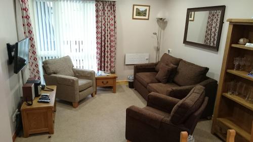 a living room with a couch and a chair at Quaysiders Lakes Resort - Quaysiders Club in Ambleside