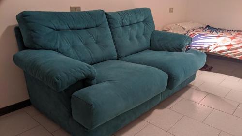 a blue couch sitting in a living room at uno spazio luminoso e tranquillo vicino Milano in San Zenone al Lambro