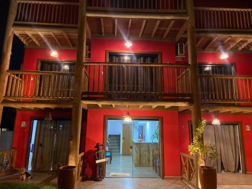 a house with red walls and wooden balconies at Pousada Amaris in Penha