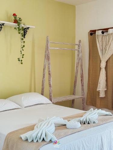 a bedroom with a bed with towels on it at Pousada Curva dos Ventos in Icaraí
