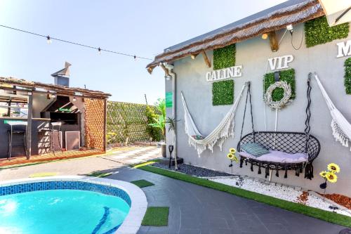 a house with a swing next to a swimming pool at Caline VIP Luxury Jacuzzi &, Swimming Pool MEWS in Cape Town