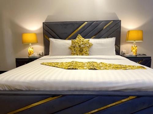 a large bed with gold sheets and pillows at Umda Safari in Islamabad