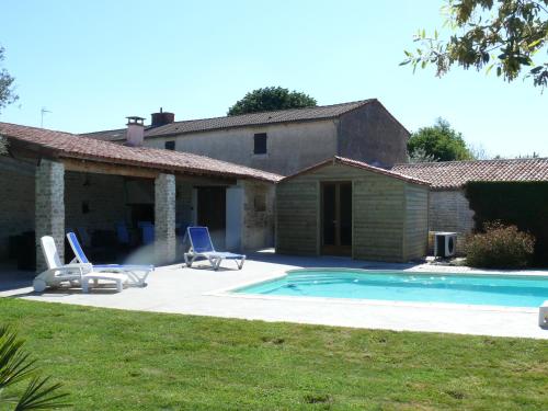 une maison avec une piscine et deux chaises longues dans l'établissement Gîte du Clos de la Vigne, à Montreuil