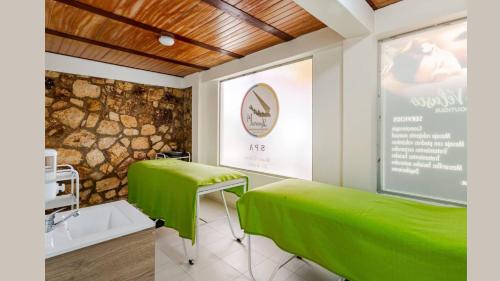 a treatment room with green beds and a sign at HOTEL BOUTIQUE 14 LANCEROS in Paipa
