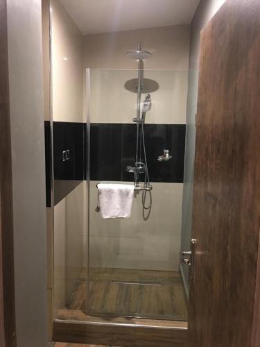 a bathroom with a shower with a glass door at La VOD Hotel in Benin City