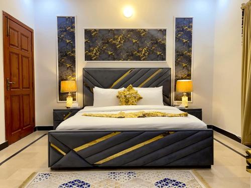 a bedroom with a large bed with a black headboard at Umda Safari in Islamabad