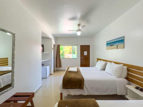 a hotel room with a bed and a mirror at Pousada Sonho de Geribá in Búzios