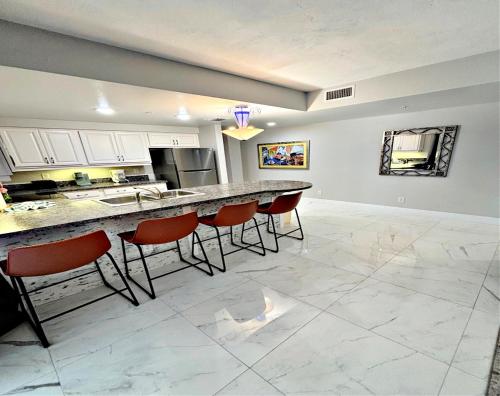 une cuisine avec un comptoir et des chaises rouges dans l'établissement 14th Floor 2 BR Resort Condo Direct Oceanfront Wyndham Ocean Walk Resort Daytona Beach 1401, à Daytona Beach