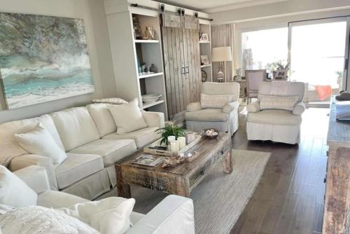a living room with white couches and a table at Regency Towers Unit 803E in Pensacola Beach