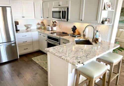 a kitchen with white cabinets and a marble counter top at Regency Towers Unit 803E in Pensacola Beach