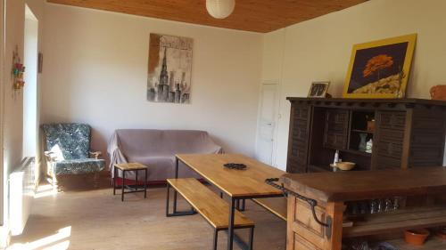 a living room with a table and a couch at Gite de l'école in Saint-Louis-et-Parahou