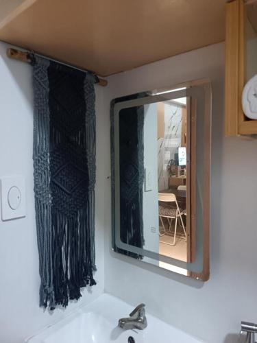 a mirror above a sink in a bathroom at Cheers SMDC Condominium in Marilao