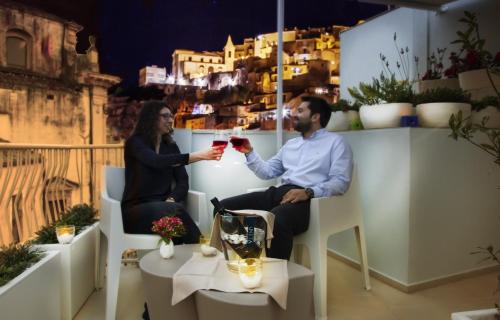 un hombre y una mujer bebiendo vino tinto en Iblaresort Boutique Hotel en Ragusa