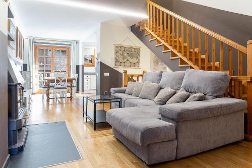 a living room with a couch and a staircase at Cerca del Puente Tibetano I Tríplex con Vistas in Canillo