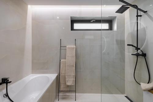 a white bathroom with a tub and a shower at BNB Family Living Hviezdoslavov in Hviezdoslavov