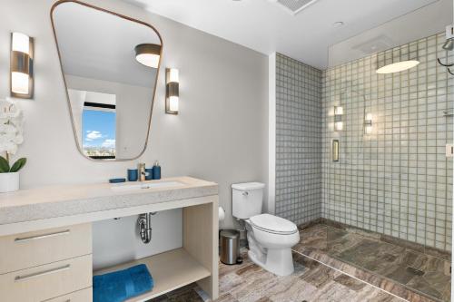 ein Badezimmer mit Toilette, Waschbecken und Spiegel in der Unterkunft Rooftop Pool Modern 2BR, 2BA - Panoramic Hollywood views in Los Angeles