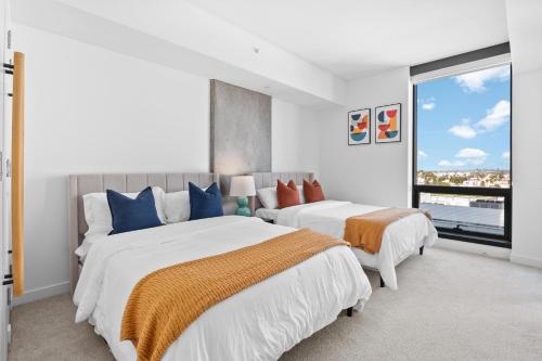 ein Schlafzimmer mit zwei Betten und einem großen Fenster in der Unterkunft Rooftop Pool Modern 2BR, 2BA - Panoramic Hollywood views in Los Angeles