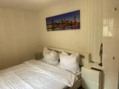 a bedroom with a bed with white sheets and pillows at Mini Bungalow in Mainz