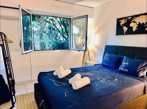 een slaapkamer met een blauw bed met handdoeken erop bij CAP THALASSA - Beau 2P - Piscine - Parking - AC in Roquebrune-Cap-Martin