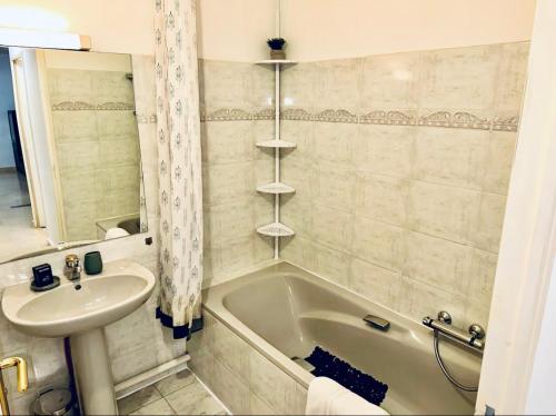 een badkamer met een wastafel en een bad en een wastafel bij CAP THALASSA - Beau 2P - Piscine - Parking - AC in Roquebrune-Cap-Martin