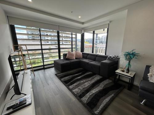 a living room with a couch and a large window at Modern coastal living with 5G & Netflix in Wollongong