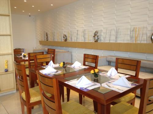 a dining room with a table and chairs with napkins at Hotel Atrium Plaza in Barranquilla