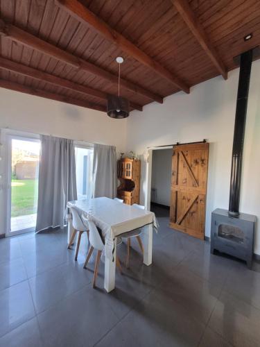 ein Esszimmer mit einem weißen Tisch und einer Holzdecke in der Unterkunft Casa fin de semana in Sierra de la Ventana