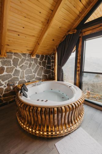 a large round tub in a room with a stone wall at Avida Bungalov in Çamlıhemşin