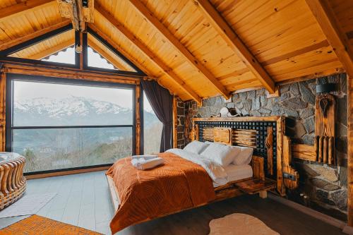 a bedroom with a bed and a large window at Avida Bungalov in Çamlıhemşin