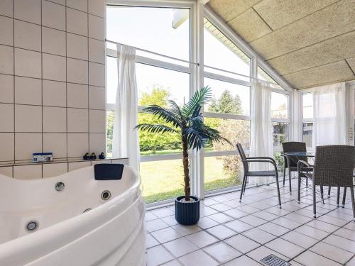 a large bathroom with a tub and a palm tree at 14 person holiday home in Væggerløse-By Traum in Marielyst