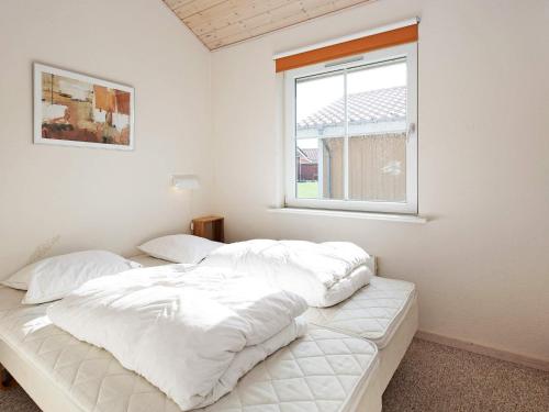 een witte slaapkamer met twee bedden en een raam bij 4 person holiday home on a holiday park in Gråsten in Gråsten