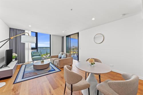 a living room with a table and chairs at Marine Quarter Apartments by CLLIX in Gold Coast