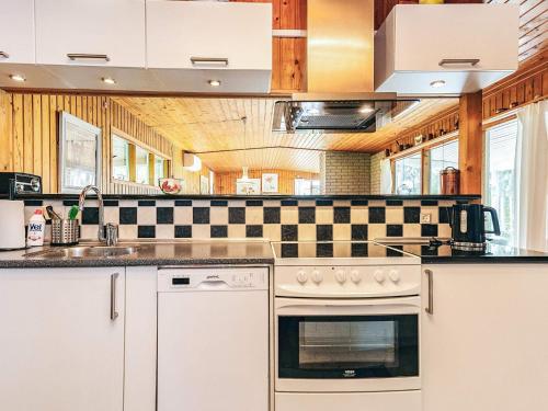 a kitchen with a stove and a sink at 6 person holiday home in Dannemare in Dannemare
