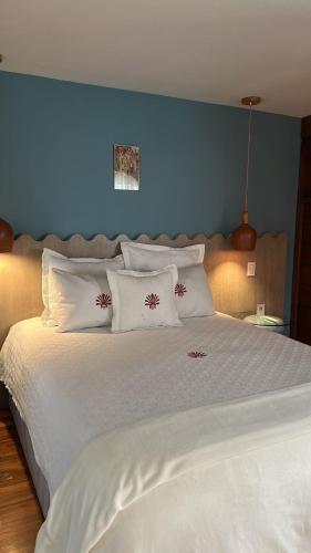 a large white bed with white pillows and a blue wall at Nokal Exclusive Stay in Mexico City