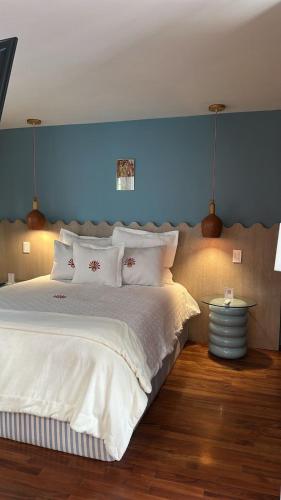a bedroom with a large white bed with a blue wall at Nokal Exclusive Stay in Mexico City