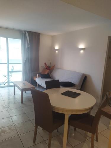 un salon avec une table et un canapé dans l'établissement Appartement de standing a 10 minutes à pied du palais festival, à Cannes