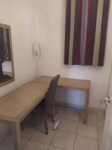 - une table en bois et une chaise dans la chambre dans l'établissement Appartement de standing a 10 minutes à pied du palais festival, à Cannes