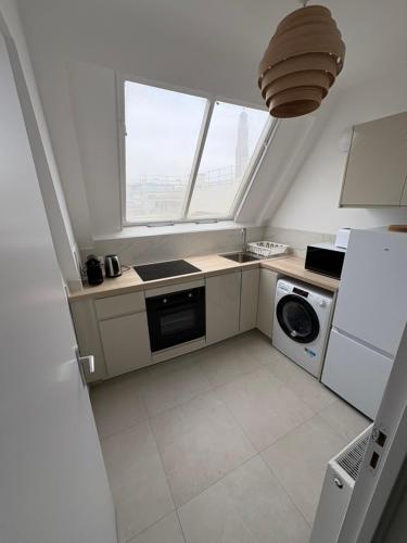 Il comprend une petite cuisine équipée d'une cuisinière et d'un lave-linge. dans l'établissement Sur les toits de Paris, à Paris